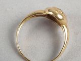 an image of a gold ring on a white surface