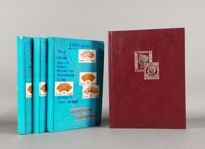trois livres sont alignés les uns à côté des autres sur une surface grise