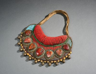 une photo d'un collier composé de perles et de pierres, posé sur une table