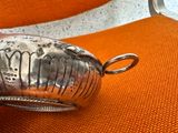 a silver object on a orange chair with a pair of scissors in it