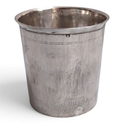 an old silver metal cup with a handle on a white background