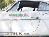 a white car with a sticker on it parked on the side of the road