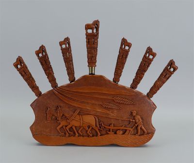 une image représentant une sculpture en bois représentant un groupe de personnes sur une colline