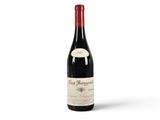 a bottle of red wine sitting on top of a white table