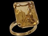 an image of a ring with a yellow stone on a black background