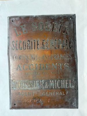 une plaque apposée sur le mur d'un immeuble, sur laquelle on peut lire « côté sud »