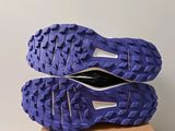 the soles of a pair of purple running shoes on top of a cardboard box