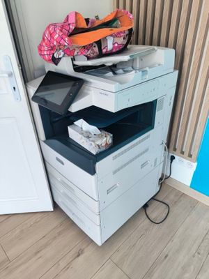 a multi - function printer sitting on the floor next to a door