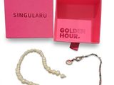 une image représentant une boîte rose contenant un collier et un collier de perles