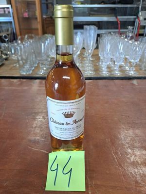 une bouteille de vin posée sur une table, avec des verres en arrière-plan