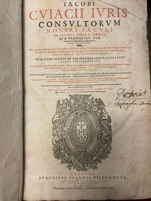 an old book with a picture of a coat of arms on top of it
