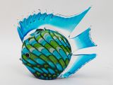 a blue and green fish figurine on a white surface