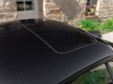 a black car parked in front of a stone building
