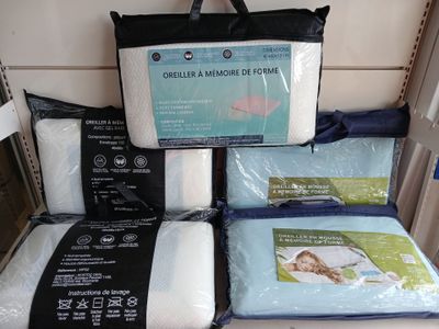 many pillows and blankets on display in a store