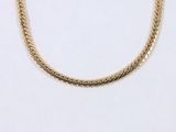 a close up of a gold chain necklace on a white background
