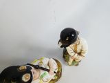 two figurines of a man and a woman sitting next to each other