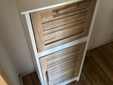 a picture of a white and wood dresser in a small room