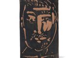 une image représentant un bloc de bois sur lequel est dessiné le visage d'un homme