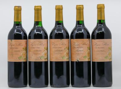 quatre bouteilles de vin sont alignées sur une surface blanche