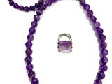 a close up of a purple necklace and bracelet with a ring