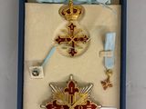 une boîte contenant une croix, une médaille, un ruban et d'autres objets