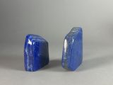 two pieces of blue stone sitting next to each other on a white surface