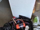 a pile of garbage on the floor next to a refrigerator