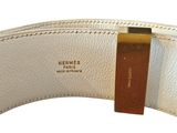 a close up of a white belt with a gold buckle