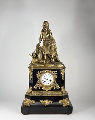 une statue représentant une femme et un chien posée sur une table