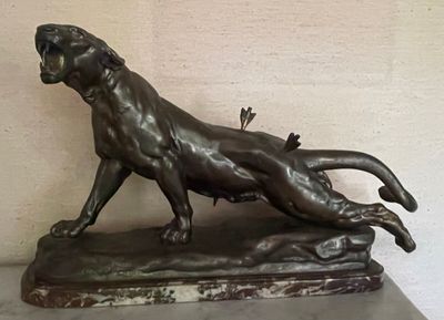 a bronze statue of a lion on a marble base