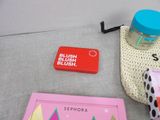 various items that are on a table with a pink bag