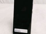 the back of a black cell phone sitting on top of a table