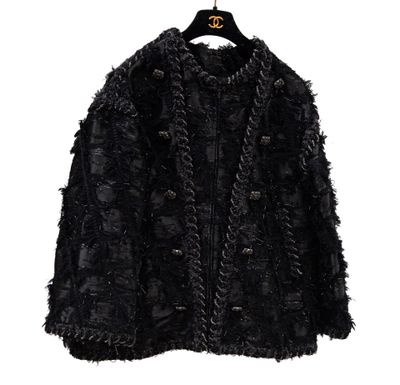 une veste noire sur un cintre, sur fond blanc
