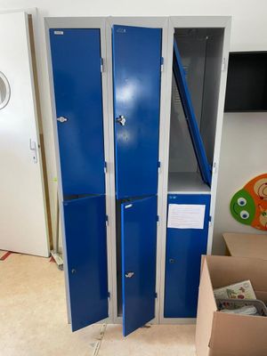 two blue lockers in a room next to a tv