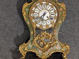 une horloge verte et dorée accrochée au mur
