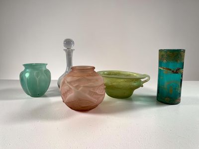 plusieurs vases en verre de différentes couleurs posés sur une table blanche