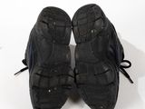 a pair of black shoes that are on a white surface