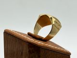 an image of a gold ring sitting on top of a wooden block