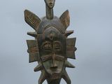 sculpture représentant un masque surmonté d'un oiseau