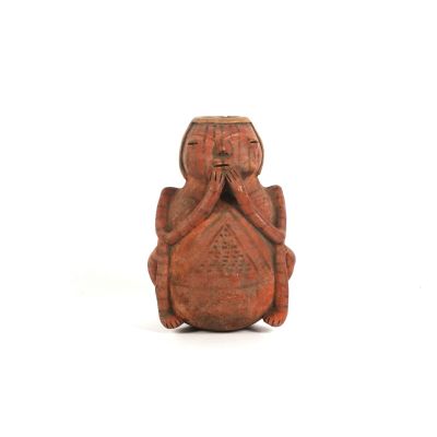 an image of a figurine of a monkey sitting on its back