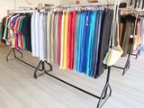 a lot of clothes hanging on a rack in a store