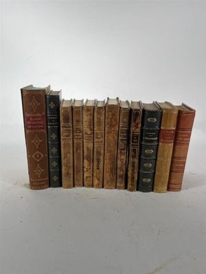 plusieurs vieux livres sont alignés sur une surface blanche