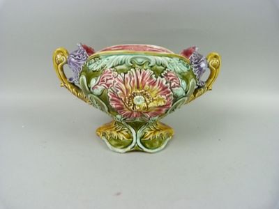 a small vase with flowers on it on a white surface
