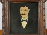 tableau représentant un homme en smoking, moustachu, dans un cadre en bois