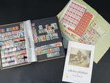 un livre ouvert sur lequel figurent des timbres et un livret avec la photo d'un bâtiment