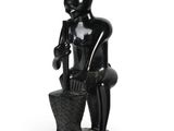 figurine noire représentant un homme assis sur un rocher, coiffé d'un chapeau