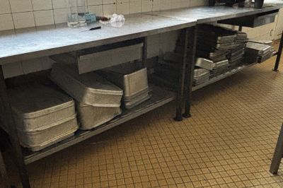 une cuisine avec un plan de travail et un évier sur lequel sont posés de nombreux plats