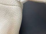 someone is holding a pair of white leather gloves on their hands