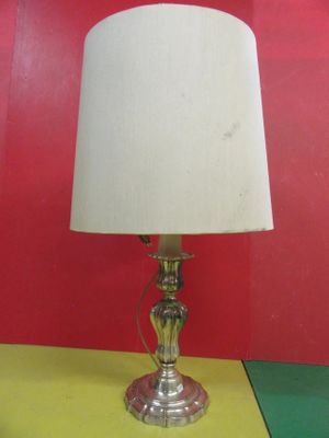 une lampe posée sur une table, avec un mur rouge en arrière-plan