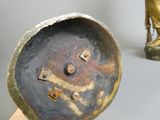 un objet métallique sur lequel figurent un crâne et des os croisés